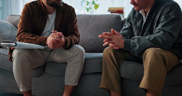 A therapist and client talking together in a bright office.
